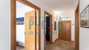 A hallway with wooden doors, a tiled floor, and a framed picture on the wall. - Villa Ilenia in Marina di Mancaversa (Taviano)