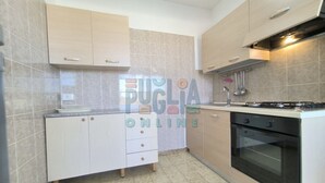 Een moderne keuken met een fornuis, oven en kasten.