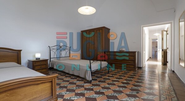 A bedroom with a bed, a nightstand, a dresser, and a wardrobe.