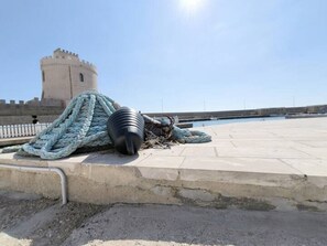 Seil und Pol auf einer Betonfläche, im Hintergrund ein Turm.