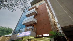 A modern building with a sign for 'Hiland Suites' and 'treebo Hiland Suites.' - Treebo Hiland Suites (Bengaluru)