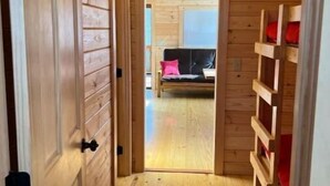 A wooden interior with a hallway leading to a bedroom.