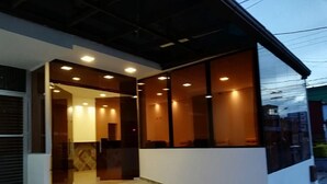 A modern building with a covered entrance, a reception area, and a staircase leading inside. - HOTEL EXPO INN AGORA  (Bogotá)