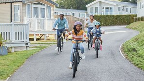 Een gezin fietst op een woonstraat met huizen aan beide zijden.