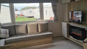 Een gezellige woonkamer met een ingebouwde bank, een flatscreen televisie en een open haard.