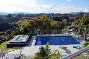 Una piscina al aire libre, sillones reclinables de piscina