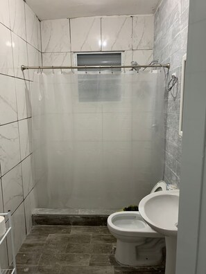 Een douche, handdoeken, zeep, shampoo