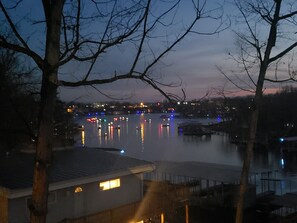A nighttime view of a waterfront area with buildings and reflections on the water.