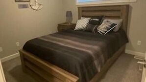 A bedroom with a bed, nightstand, and ceiling fan.