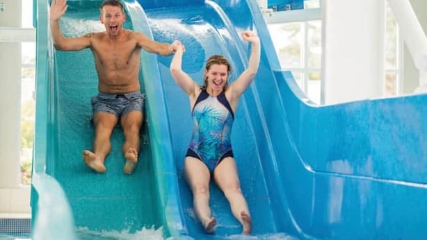 A water slide with two people sliding down.