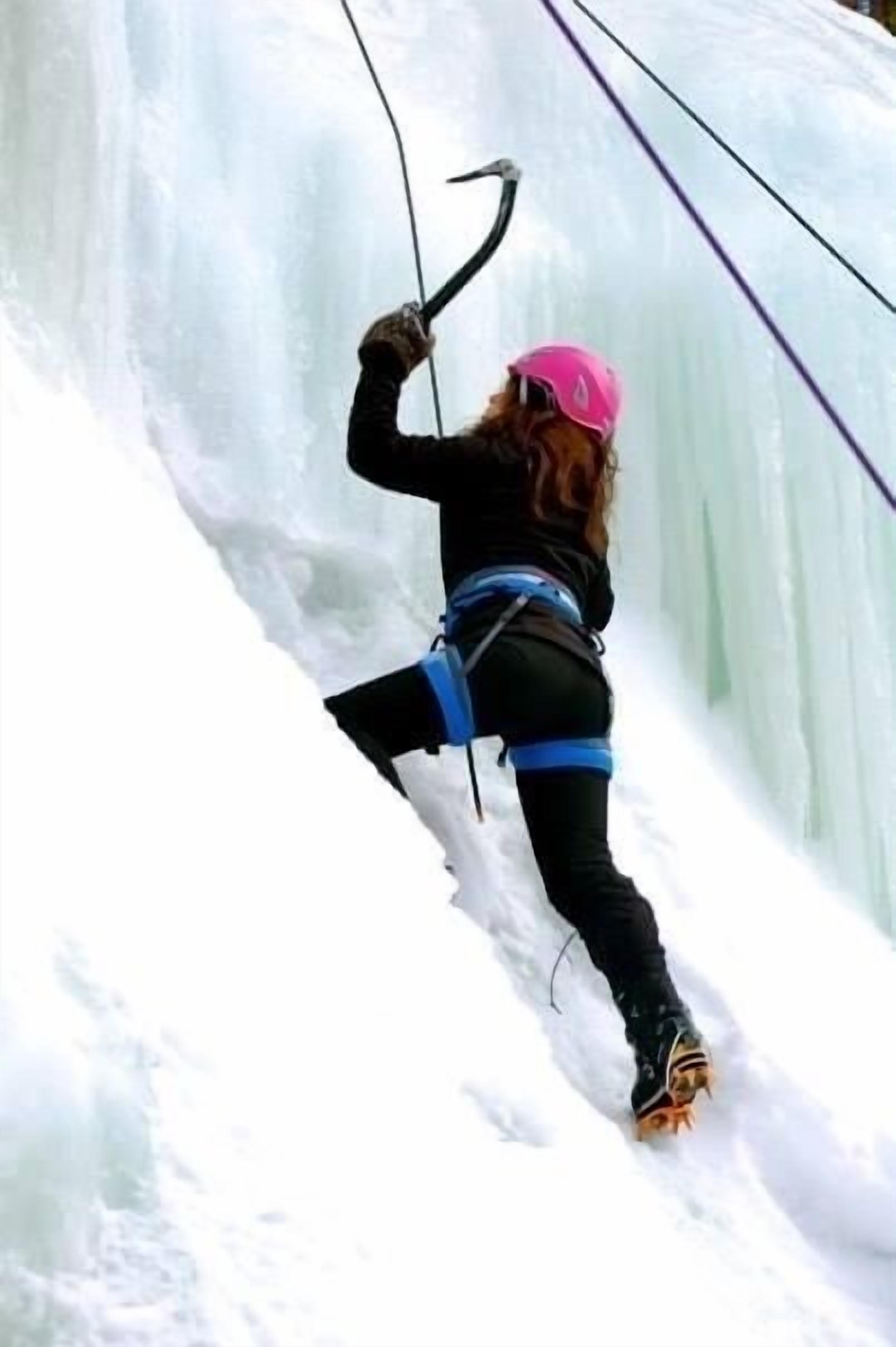 A person ice climbing with safety gear.