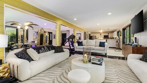 A modern living room with a sofa, coffee table, and a television. - Peaceful Luxury Unique 3 BDR Home w/ Cinema & More (Traverse City)