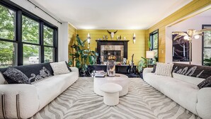 A modern living room with two sofas, a central coffee table, and a fireplace. - Peaceful Luxury Unique 3 BDR Home w/ Cinema & More (Traverse City)