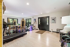 Un amplio salón con un espejo grande, una chimenea y un sillón decorativo.