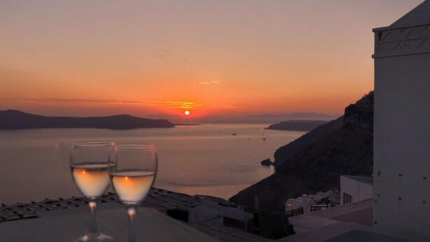 A sunset view from a terrace with two glasses of white wine. - Tatakis Design Hotel, Fira (Santorini)