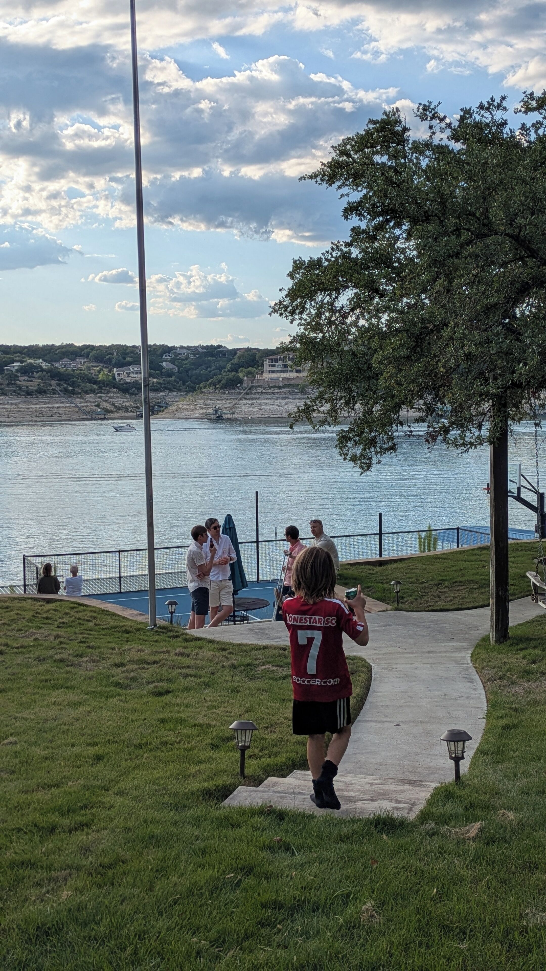 A pathway leading to a waterfront area with a view of the water and distant buildings.