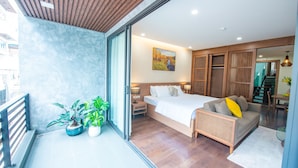 A modern bedroom with a large bed, a sofa, and a dining area. - J'adore Apartment (Hanoi)
