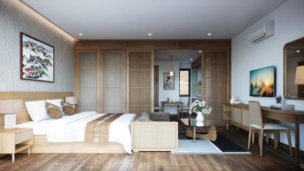 A modern hotel room with a large bed, a desk, and a seating area. - J'adore Apartment (Hanoi)