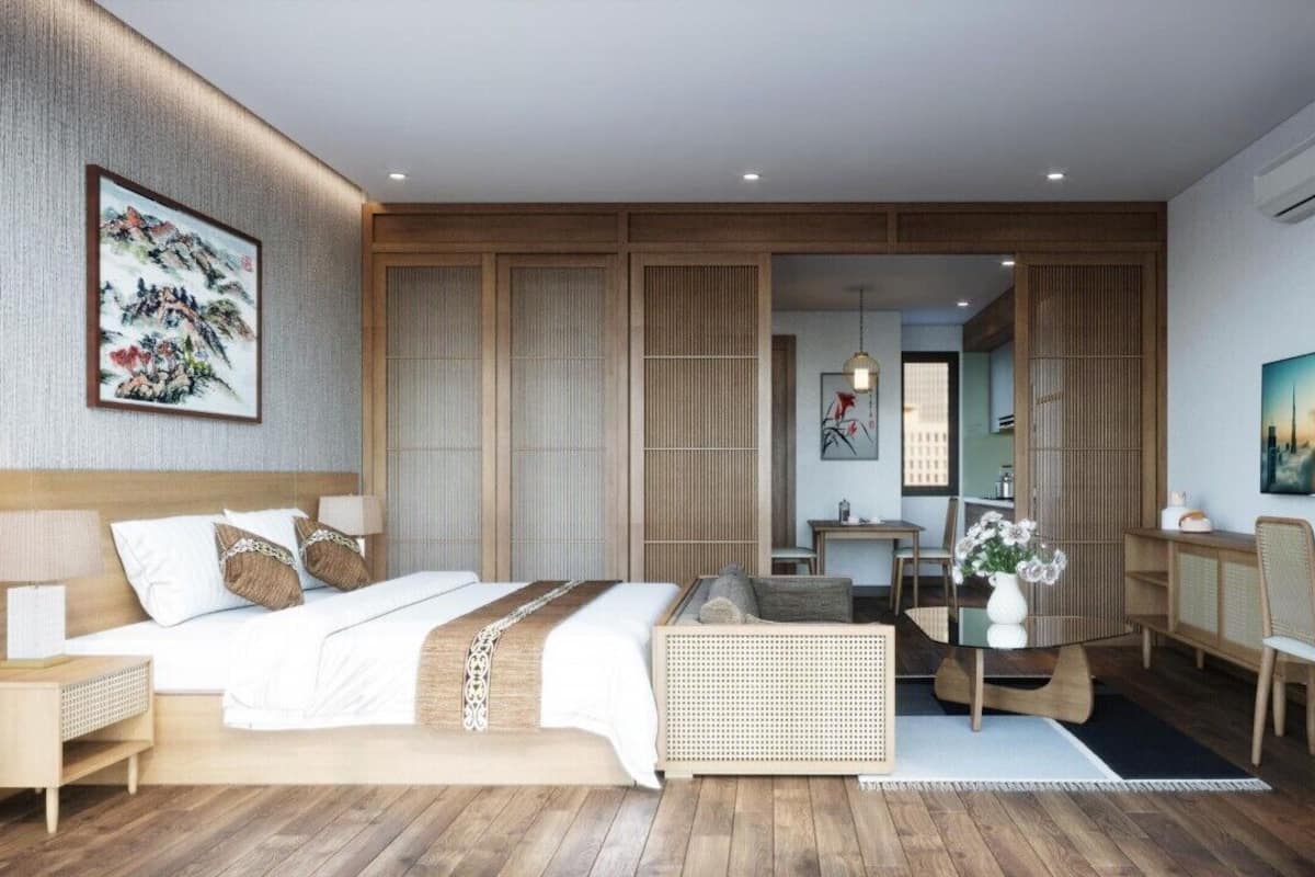 A modern hotel room with a large bed, a desk, and a seating area.