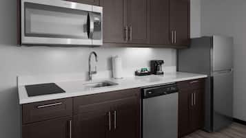 A modern kitchen with dark brown cabinets, stainless steel appliances, a dishwasher, and a coffee maker.