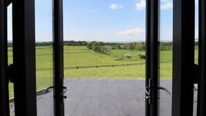 Ein offenes Portal mit Blick auf ein grünes Feld und Bäume.