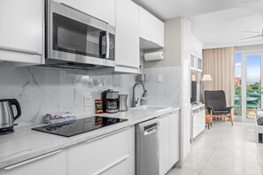 A modern kitchen with a built-in microwave, coffee maker, and dishwasher.