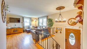Un salon spacieux doté de parquets en bois, d’un escalier et d’un coin salon confortable.