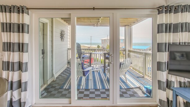 A balcony with a checkered floor, a view of the beach, and a fan. - Ocean-View Balcony: Carolina Beach Condo! (Carolina Beach)