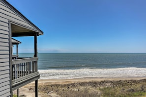 A beachfront property with a wooden deck overlooking the ocean.