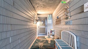 A narrow hallway with wooden walls, a starfish-patterned rug, a bench, and a 'Welcome' sign. - Topsail Beach Oceanfront Oasis w/ Stunning Views! (Sneads Ferry)