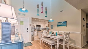 A dining area with a white table and bench, a blue lamp, and decorative fish on the wall. - Topsail Beach Oceanfront Oasis w/ Stunning Views! (Sneads Ferry)