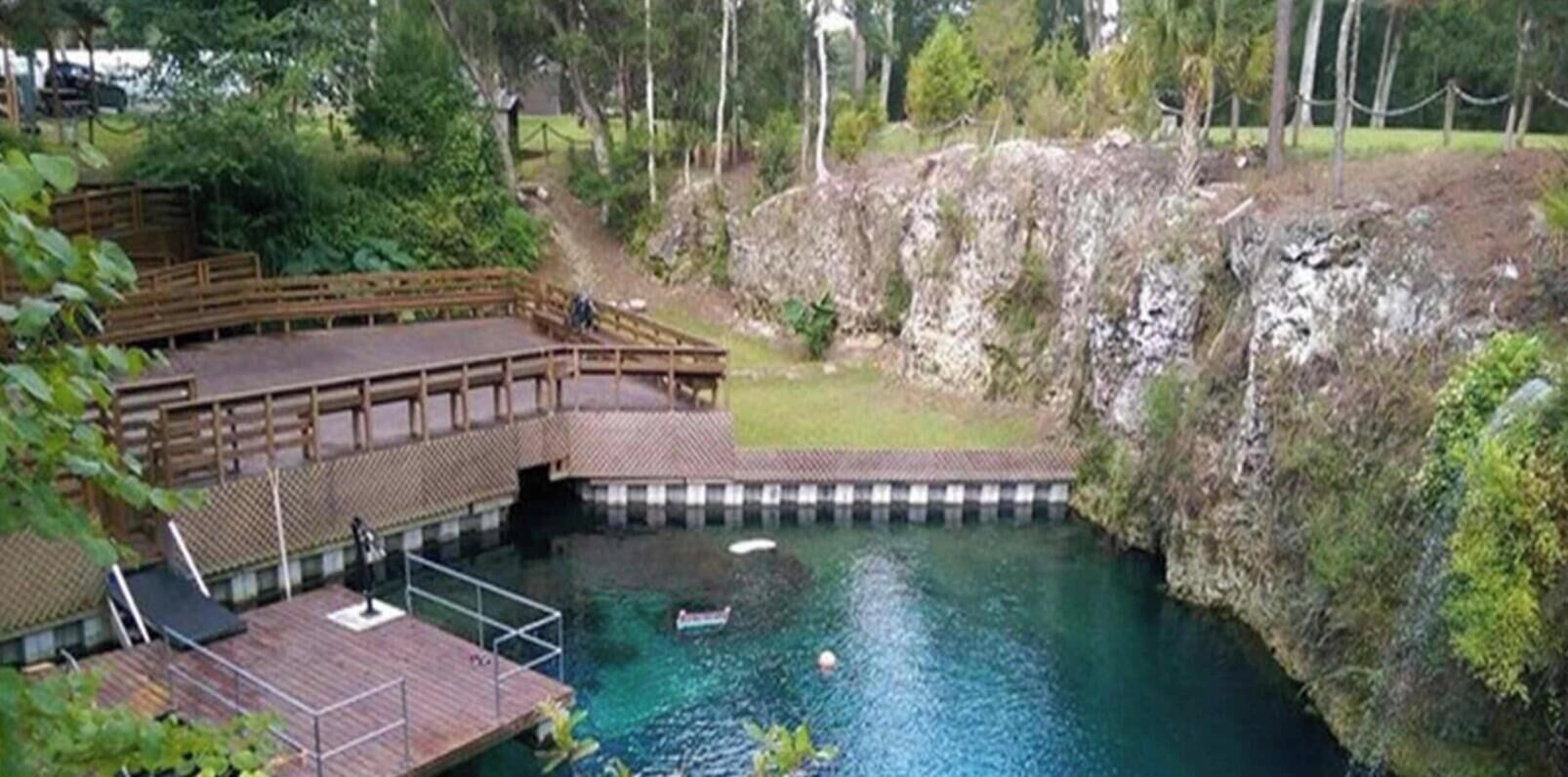 A swimming pool with a wooden deck and a small boat.