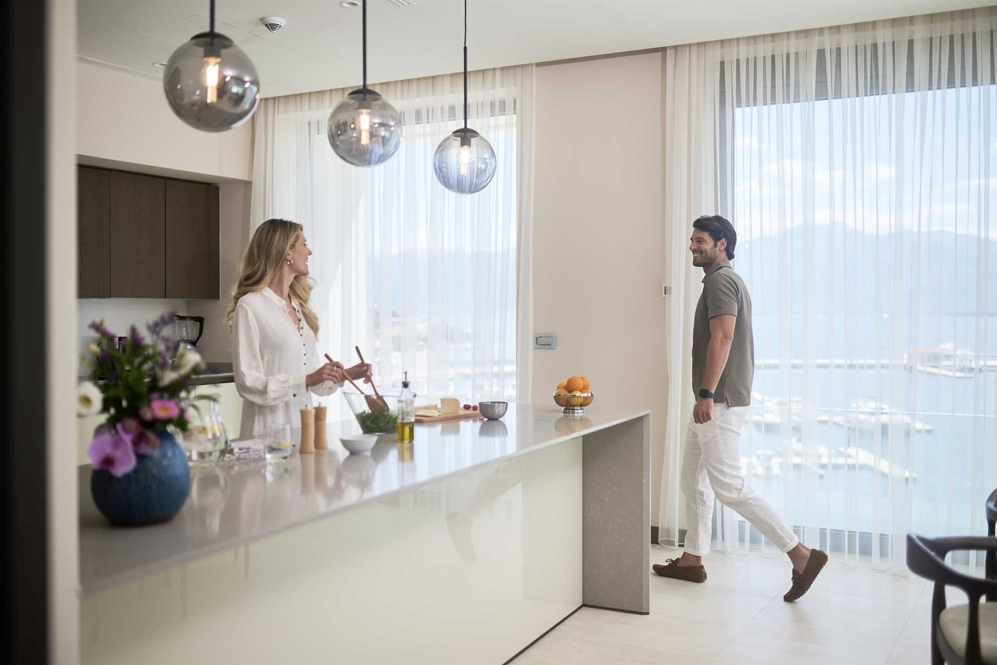 A modern kitchen with a central island, large windows, and a view of the city.