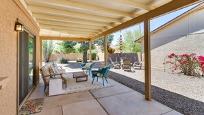 A covered patio area with outdoor furniture, a pergola, and a view of the backyard.