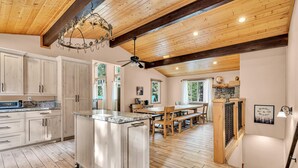 A spacious kitchen with wooden cabinets, a large island, and a dining area with a wooden table and chairs.