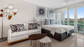 A modern bedroom with a bed, a sofa, a coffee table, and a balcony with a view. - Sunrise Studio · Balcony · Water Backup (San Juan)