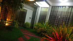 A garden pathway leading to a house with a green lawn and red brick accents. - Randima Hotels (Negombo)