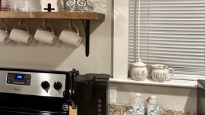 A kitchen with a Whirlpool stove, a coffee maker, and a sign that reads "BE OUR Guest". - House in Forney (Forney)