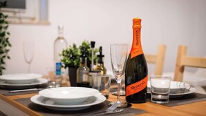 A dining table set with plates, a wine glass, and a bottle of Monnetto Prosecco. - Mola Apartments-Wetter/ 5 P/Parking/Terrasse/Grill (Wetter (Ruhr))