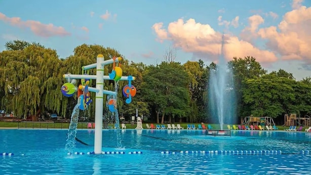 A swimming pool with a water play structure and a fountain. - Falcon Cottages (Niagara-on-the-Lake)
