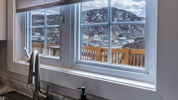 A kitchen with a window overlooking a snowy landscape.