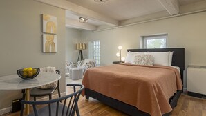 Une chambre à coucher avec un lit, une table de chevet et une petite table ronde avec des chaises.