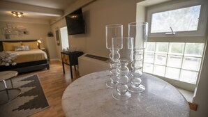 A bedroom with a bed, bedside table, and a window with a view. - Stylish Queen Suite Near SIU Carbondale (Carbondale)
