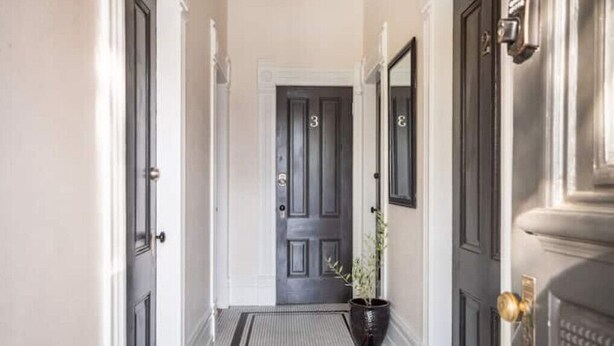 A hallway with three doors, each marked with a number. - Sac City Loft (Sacramento)