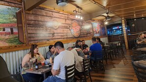 Un restaurante con paredes de madera y un mural, que incluye mesas y sillas para comer.