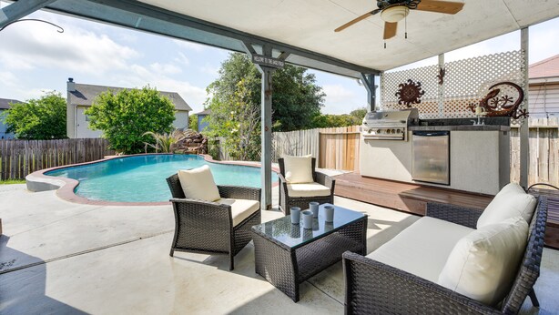 A covered outdoor patio with a pool, wicker furniture, a ceiling fan, and a barbecue grill. - San Antonio Home w/ Private Hot Tub + Pool! (San Antonio)