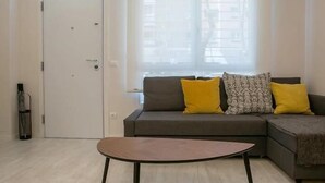 Ein Wohnzimmer mit einer Couch, einem Couchtisch und einer Tür.