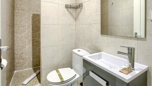 A modern bathroom with a shower, toilet, sink, and a mirror. - Callao Central - Renovated and Central Apartment (Madrid)