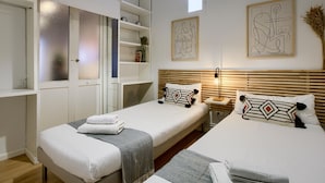 Ein Schlafzimmer mit zwei Betten, einem Kleiderschrank und Bildern an den Wänden.