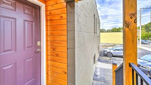 A purple door with a metal handle, a wooden exterior, and a concrete wall.